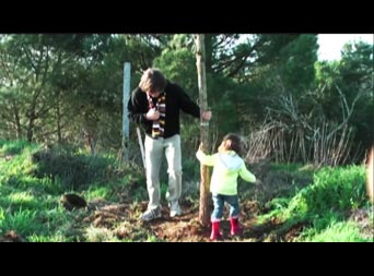 Harm en een klein meisje planten samen een Zwarte Walnootboom
